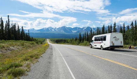 Yukon und Alaska Rundreise Tourbus vor Bergkulisse